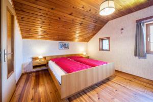 a large bed in a room with a wooden ceiling at Urthalerhof Historic in Valdaora