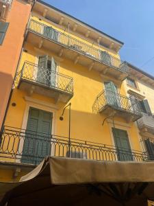 un edificio amarillo con balcones y ventanas en Arena Apartment Verona, en Verona
