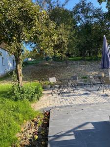 a patio with chairs and an umbrella in a park at Ferienwohnung Louis in Passau +3 photos