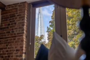 a view of the burj khalifa through a window at Newly Refurbished Warehouse Cnv 2BR Apt Bermondsey in London