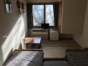 a room with two beds and a table and a window at New Togakushi Sea Hail - Vacation STAY 61014v in Nagano