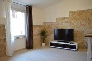 sala de estar con TV de pantalla plana en un soporte en Central Apartment Adria, en Rovinj