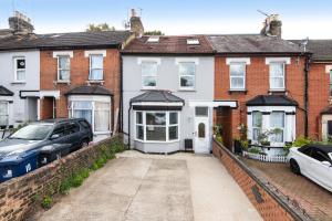 a house with a car parked in front of it at Ground Floor En-Suite Room with a Private Kitchen and Parking in a 5-Bedroom House at Hanwell in Hanwell