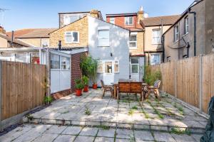 a small backyard with a wooden fence and a table at Ground Floor En-Suite Room with a Private Kitchen and Parking in a 5-Bedroom House at Hanwell in Hanwell