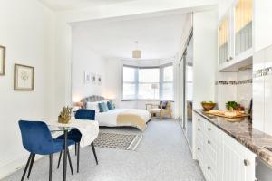 um quarto com uma cama, uma mesa e cadeiras em Ground Floor En-Suite Room with a Private Kitchen and Parking in a 5-Bedroom House at Hanwell em Hanwell