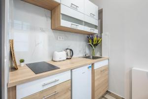 a kitchen with white cabinets and a counter top at Central New Cozy in Budapest