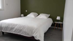 a bedroom with a white bed and a green wall at Gîte La Belle étoile - Paray-le-Monial in Paray-le-Monial