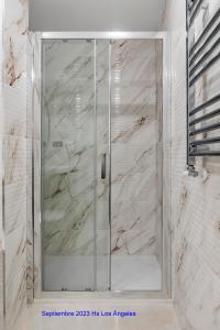 y baño con ducha y puerta de cristal. en Hostal Los Ángeles en Madrid