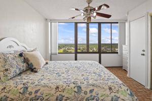 a bedroom with a bed and a ceiling fan at Nautilus Sunset Escape 801 | Flagler Beach in Flagler Beach