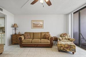 a living room with a couch and a chair at Nautilus Sunset Escape 801 | Flagler Beach in Flagler Beach +42 photos