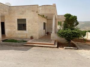 a large stone building with stairs in front of it at Full furnitured house بيت مفروش للأيجار in Sūf