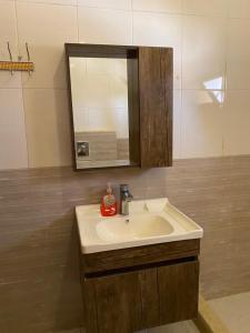 a bathroom with a sink and a mirror at Full furnitured house بيت مفروش للأيجار in Sūf