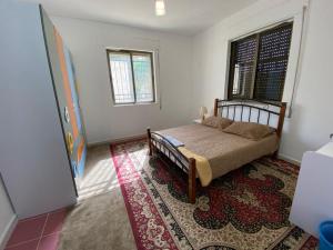 a bedroom with a bed and a rug at Full furnitured house بيت مفروش للأيجار in Sūf