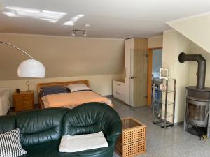 ein Wohnzimmer mit einem Sofa und einem Bett in der Unterkunft Idyllische Dachgeschosswohnung in Wittenburg