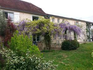 una casa con una corona de flores púrpuras. en De couleurs et d'eau fraîche, en Navarrenx