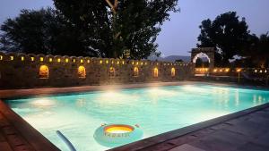a swimming pool in front of a stone wall at BluO Sariska - LUXE Stays Collection in Tehla