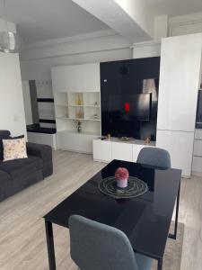 een woonkamer met een tafel en een bank bij Divine Comfort Apartments Palas Mall in Iaşi