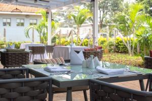 een tafel en stoelen in een restaurant met een patio bij Ulwazi Place Hotel by Trianum in Nairobi