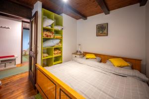 ein Schlafzimmer mit einem großen Bett mit gelben Kissen in der Unterkunft Svjetlost in Jahorina