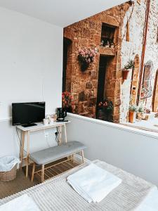 Habitación con escritorio, ordenador y pared de ladrillo. en The Red Lion Inn, en Rothwell