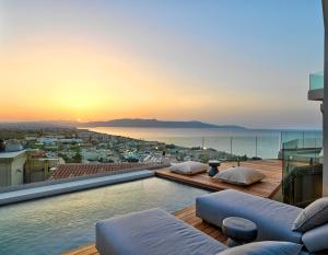a swimming pool on top of a building with a sunset at Alectrona Living Crete, Villa Ãcro in Plataniás +90 photos