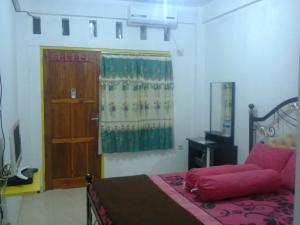 a bedroom with a bed and a door and a window at Dasi Guesthouse in Ende