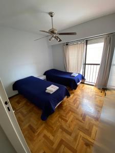 Habitación con 2 camas y ventilador de techo. en Amplio, moderno y céntrico. Departamento en Plaza Independencia en Mendoza