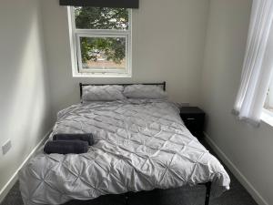 a bed in a white bedroom with a window at Swinefleet Maisonettes. Airy, Modern & Chic! in Goole