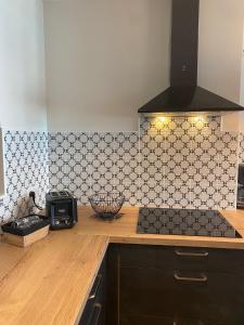 a kitchen with a black and white tiled wall at Marianne 3 in Bergerac +16 photos