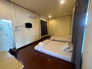 een hotelkamer met 2 bedden en een televisie bij โฮมสเตย์ภูมิใจ เชียงคาน ซอย 17 in Loei