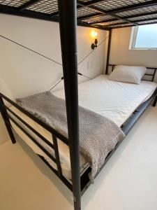 two bunk beds in a room with a window at En- Hostel & Café bar in Amami