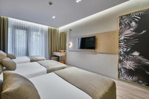 um quarto de hotel com três camas e uma televisão de ecrã plano em Rayelin Hotel Istanbul Old City Special Category em Istambul