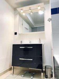 baño con lavabo negro y espejo en Hyper centre & parking privé - Le cocon T2 -Amiens, en Amiens