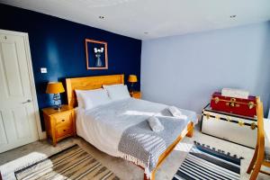 a bedroom with a bed and a blue wall at Modern 3 bed w/ garden, nr beach in Parkstone