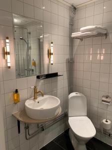 a white bathroom with a sink and a toilet at Nybro Stora Hotellet in Nybro