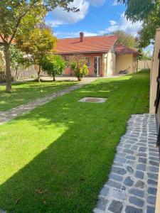 ein Haus mit einem grünen Hof mit Gehweg in der Unterkunft CONFORT HOUSE in Lugoj