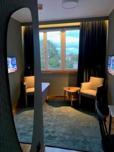 Nybro Stora Hotellet في نيبرو: مرآة تعكس صورة غرفة مع نافذة