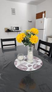 Un jarrón de flores amarillas sobre una mesa. en Dúplex Iselin - Capo Bianco, en San Rafael