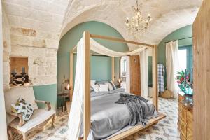 - une chambre avec un lit à baldaquin et une chaise dans l'établissement Bambarone La Masseria, à Fasano