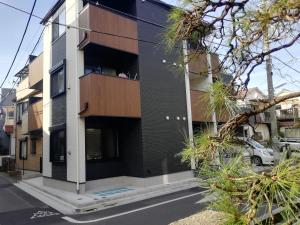 a black and white building with a balcony at KIKI HOUSE 新小岩 in Tokyo