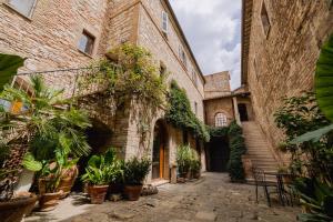 a courtyard of an old brick building with plants at Casa Dalia, colazione inclusa e vista panoramica in Assisi