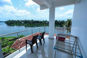 a balcony with two chairs and a view of the water at HISHAMS BHAVAN in Alwaye
