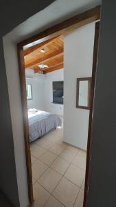 Una puerta a un dormitorio con una cama en una habitación. en Dúplex Iselin - Capo Bianco, en San Rafael