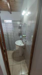 Un baño blanco con lavabo y ducha. en Dúplex Iselin - Capo Bianco, en San Rafael
