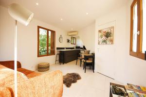 uma sala de estar com um sofá e uma secretária em Studio - Confort - Climatisé - Le Refuge de Charles - Jardin em Bures-sur-Yvette