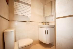 a white bathroom with a toilet and a sink at Studio - Confort - Climatisé - Le Refuge de Charles - Jardin in Bures-sur-Yvette