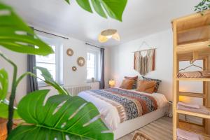 um quarto com uma cama e uma planta em Eglise 26 Aparthotels em La-Roche-en-Ardenne