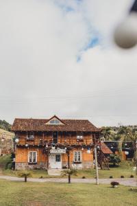 an old wooden house in the middle of a field at Casarão Biazolli in Farroupilha