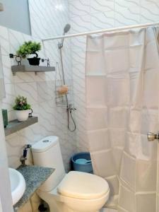 a white bathroom with a toilet and a sink at Miestee's Happy Homes in Lapu Lapu City +27 photos