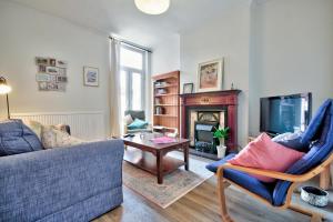a living room with a couch and a fireplace at Fliss's House in Leicester
